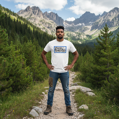 Man standing on a mountain path wearing a white t-shirt with a logo.